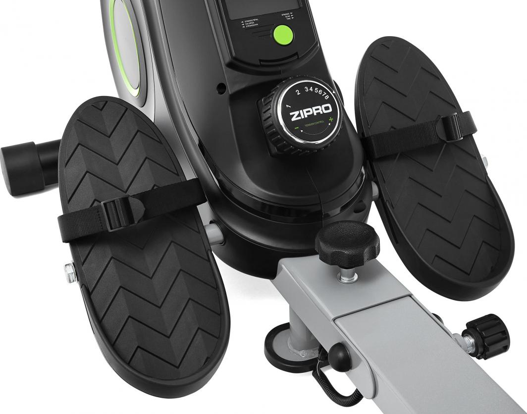 Romaskin Sammenleggbar med to sorte pedaler med stropper og et rundt justeringshjul mellom pedalene.