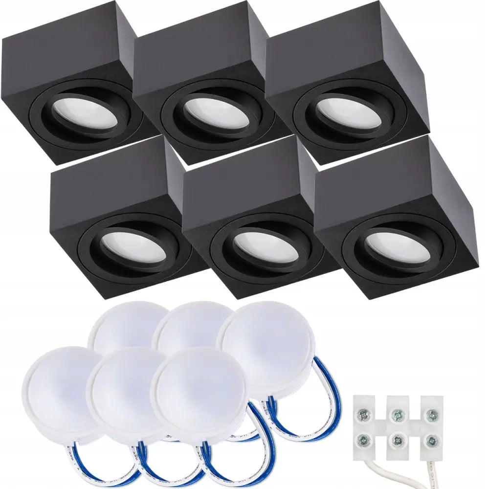 Overflatemontert halogen spot tube med seks sorte spotlights, tilhørende LED-moduler og hvit koblingsklemme.