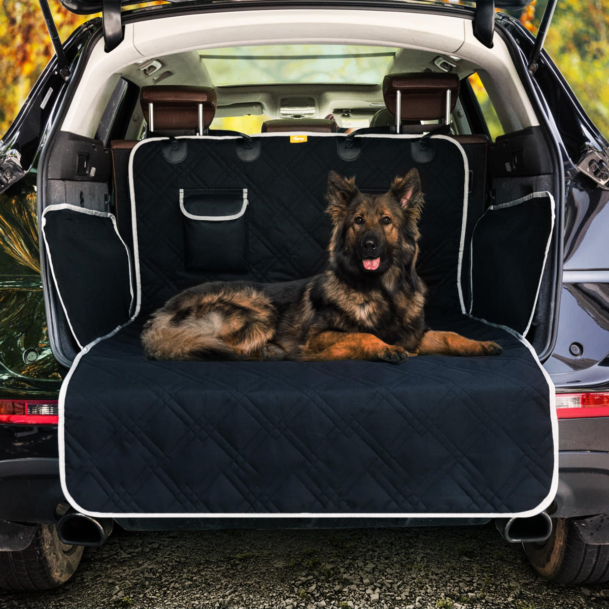 Bagasjeromstrekk Hund i sort quiltet stoff med hvite kanter, plassert i bil med stor hund liggende oppå.