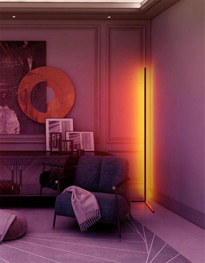 Tredemølle hjemme gulvlampe Mozos LC-RGB lyser oransje og gult i stuehjørne med moderne stol.