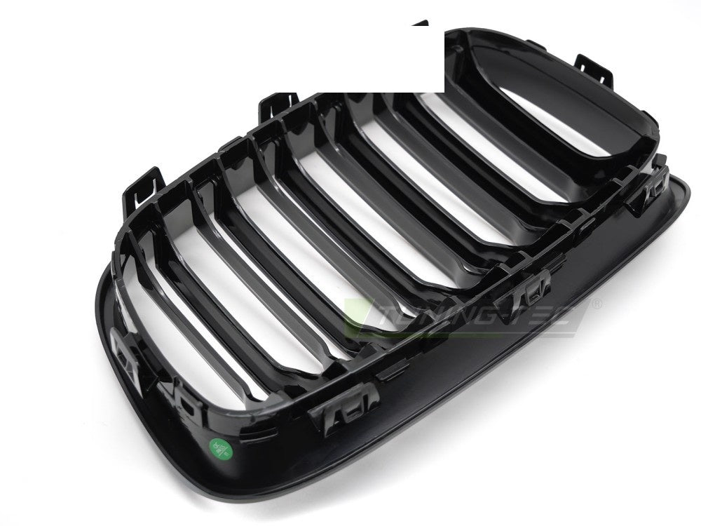 Nærbilde av glossy black double bar grill montert på BMW F20 F21