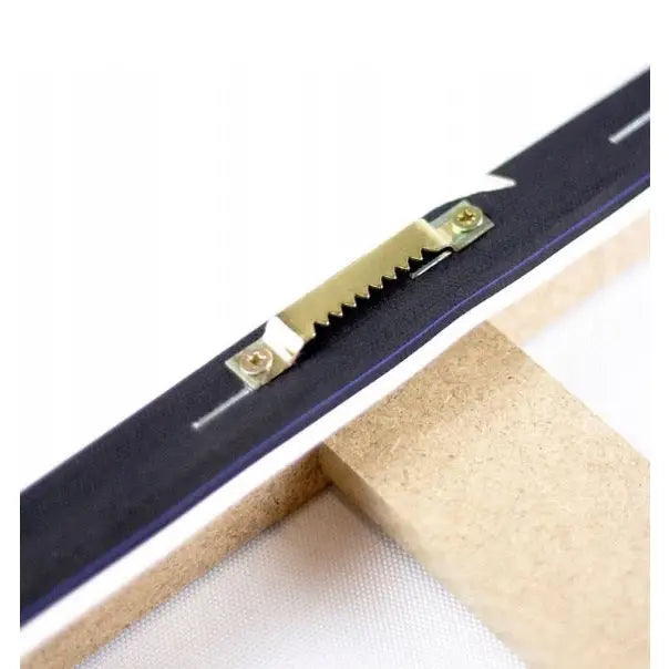 Nærbilde av metallkrok montert på sortkantet treramme for abstrakt gull og blått lerretsbilde.