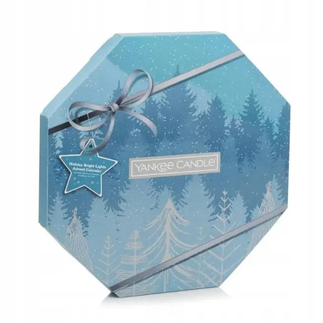 Adventskalender Krans Yankee Candle, sekskantet blå gaveeske med vintermotiv, grå sløyfe og stjerneetikett.