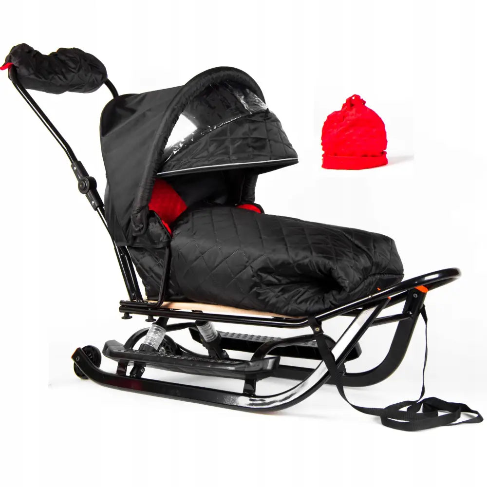 Akebrett Jee med hjul, sort modell med kalesje, vattert trekk, rød lue og synlig treplate på sittedelen.