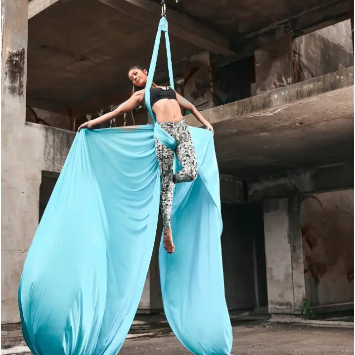 Akrobatisk silkesjerf 7 meter, lyseblå silkeduk brukt til luftakrobatikk i industrilokale, sett forfra.