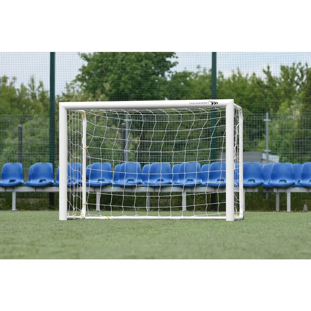 Aluminiumport MINI PRO, hvitt fotballmål med nett vist forfra mot blå seter på kunstgressbane.