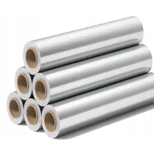 Aluminiumsfolie til catering, seks sølvfargede ruller stablet med synlige beige papprør, skrå vinkel.