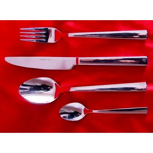 Ambition 24 X bestikksett, fire blanke deler i rustfritt stål på rød stoffbakgrunn, moderne design.