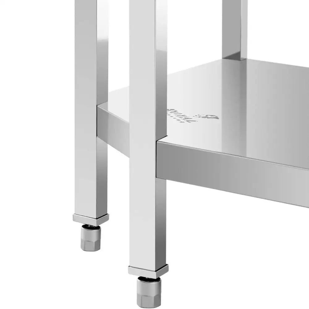 Arbeidsbenk hjørnebord i rustfritt stål, detalj av hjørne med justerbare føtter og underliggende hylle.