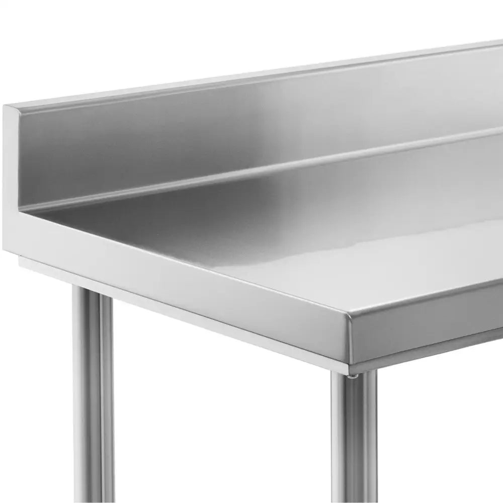 Arbeidsbenk i rustfritt stål, skrå vinkel med glatt overflate, rette kanter og opphøyd bakant mot vegg.