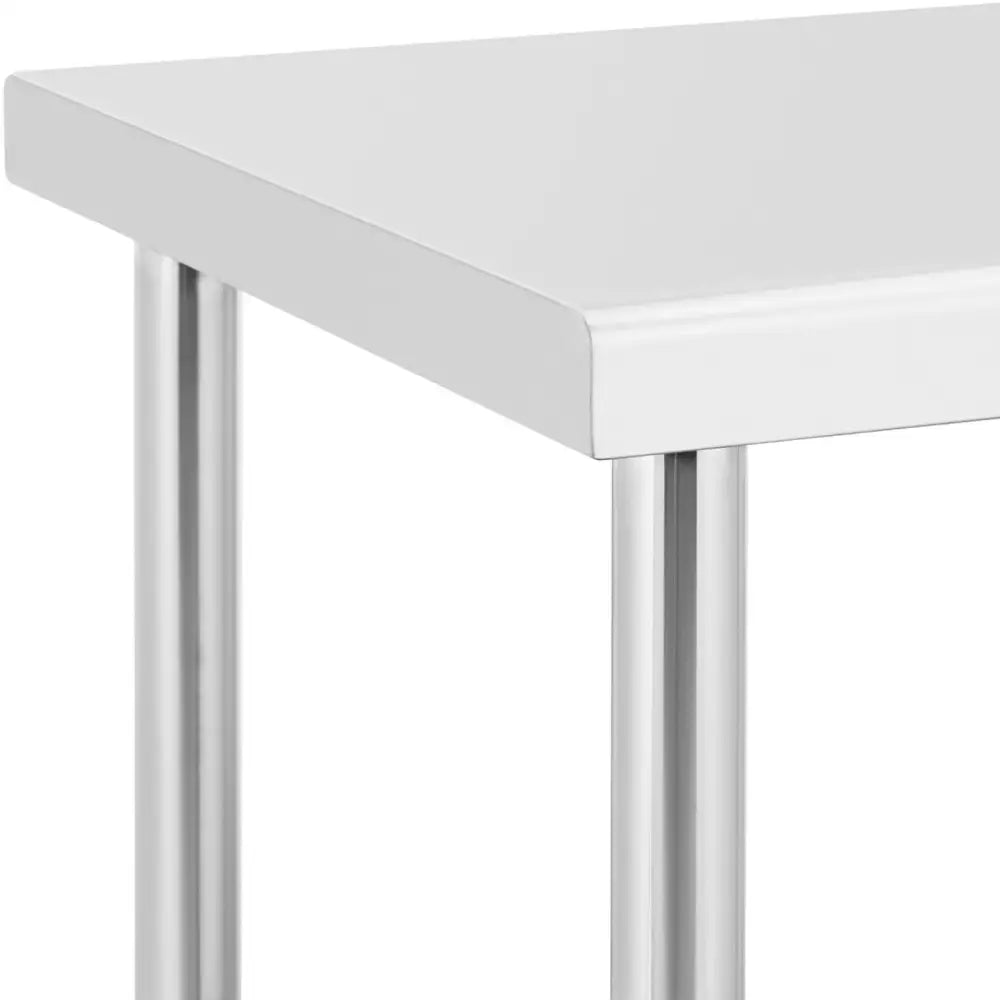 Arbeidsbenk med stålbord, nærbilde av hvitt bordhjørne og blanke, runde metallben sett fra siden.