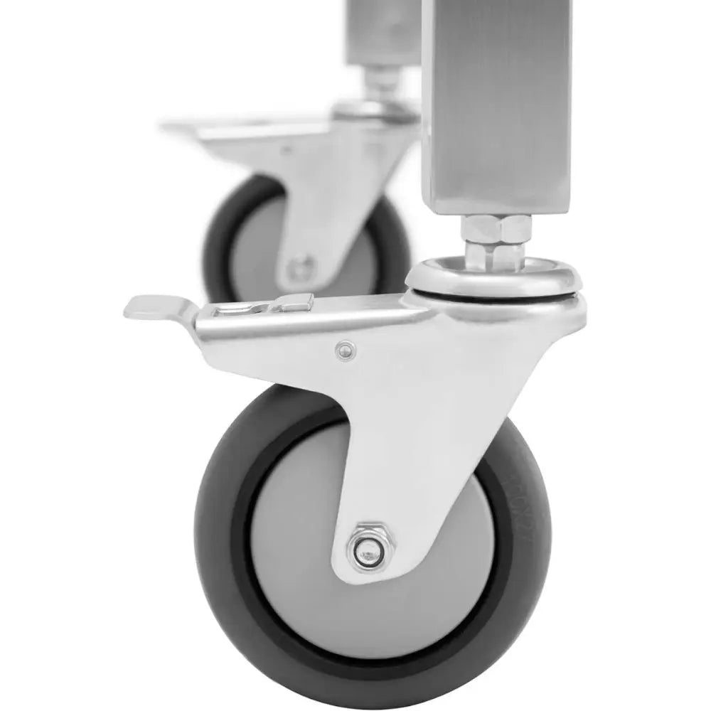 To hjul med grå gummibelegg og metallfeste på arbeidsbenk, nærbilde med synlig bremsespak og bolter.