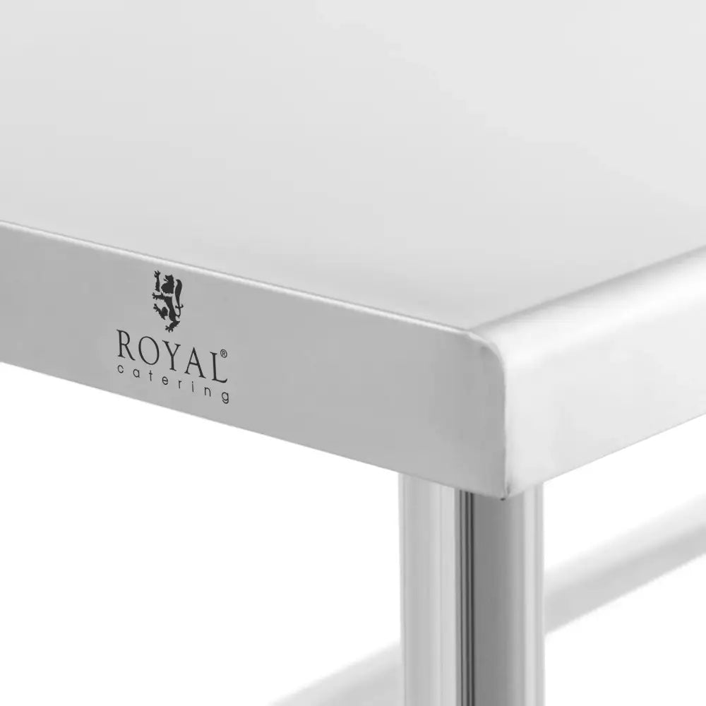 Arbeidsbord i stål, nærbilde av hjørne med glatt overflate og Royal Catering-logo trykket på langsiden.
