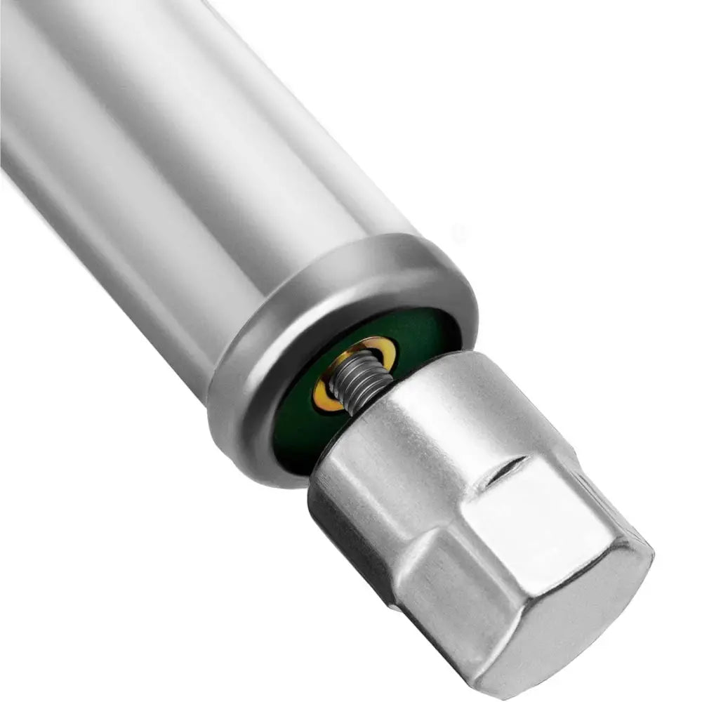 Metallisk sylinder med gjenge og sekskantet ende, skrue og grønne detaljer til arbeidsbord.