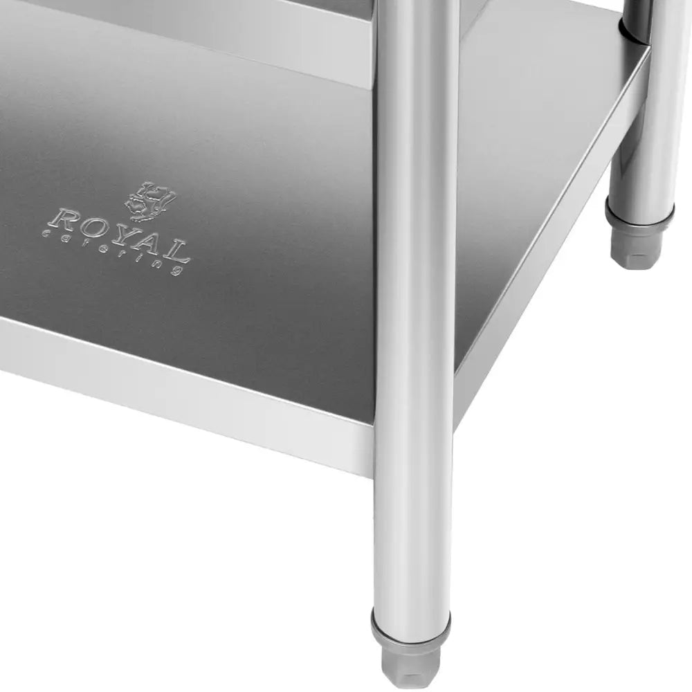 Arbeidsbord i rustfritt stål, nærbilde av nedre hylle med synlig logo, runde ben og justerbare plastføtter.