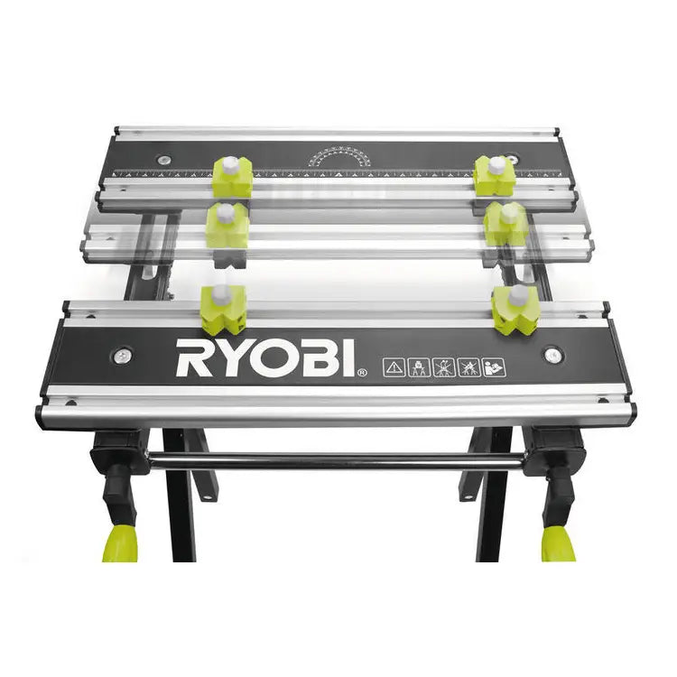 Ryobi arbeidsbord med seks grønne justeringsknapper og målelinjer på sort arbeidsflate, sett ovenfra.
