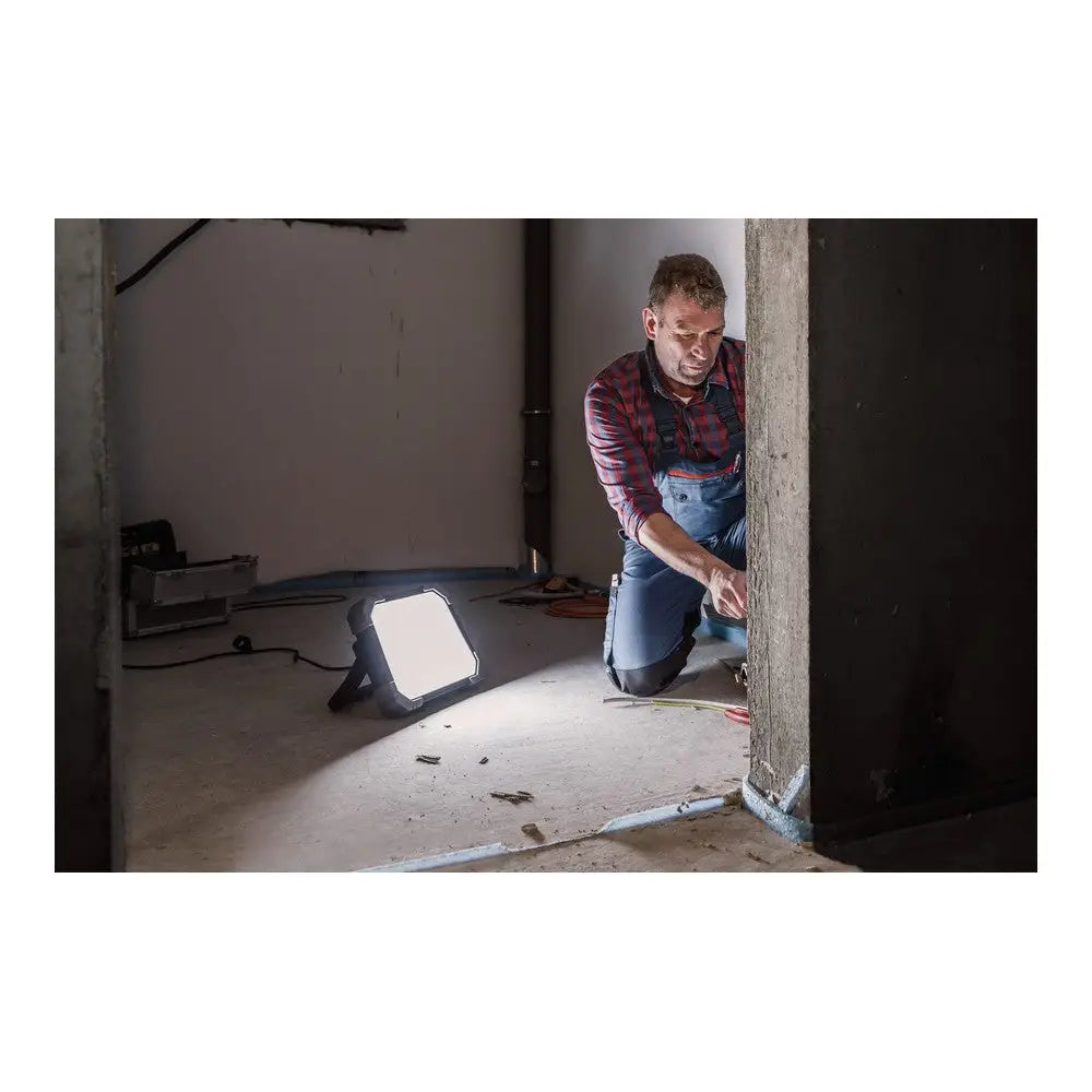 LED arbeidslys DINORA 8061, plassert på gulvet og lyser opp arbeidsområde ved betongsøyle under oppussing.