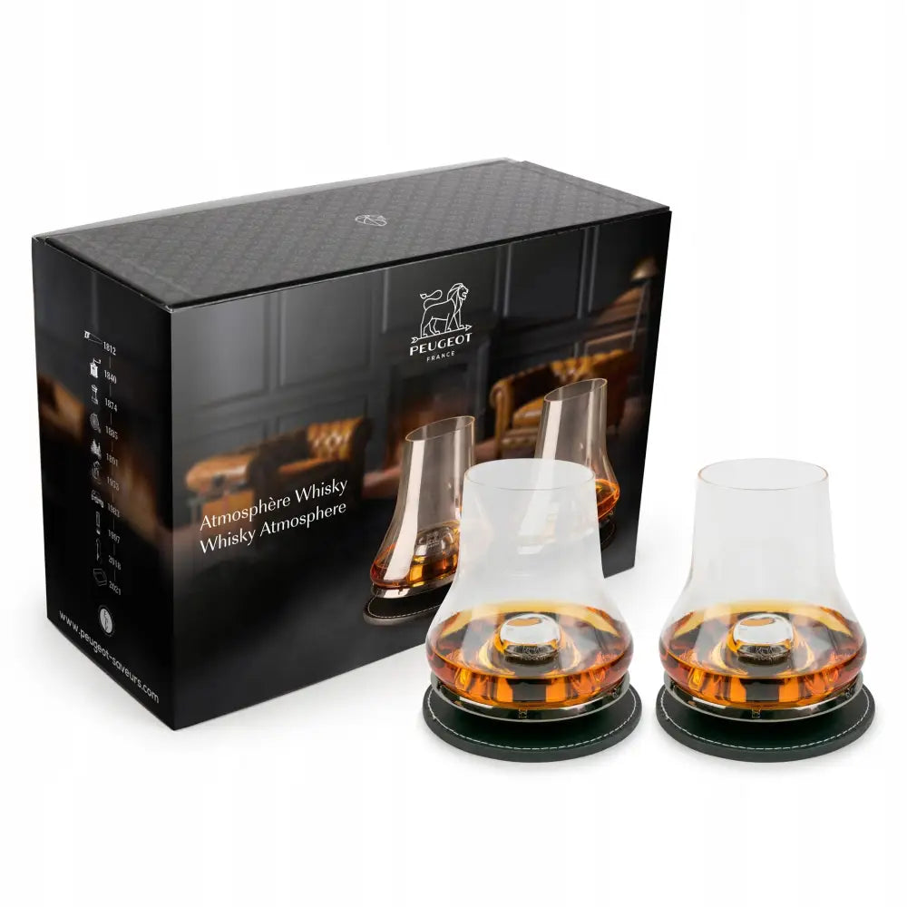 Atmosphere whiskyglass fra Peugeot, to glass med bred bunn og brun whisky på mørke coasters foran gaveeske.