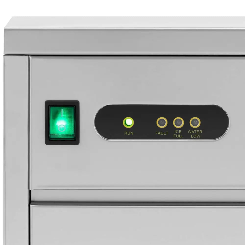 Frontpanel på automatisk ismaskin i rustfritt stål med grønn av/på-bryter og flere indikatorlamper.