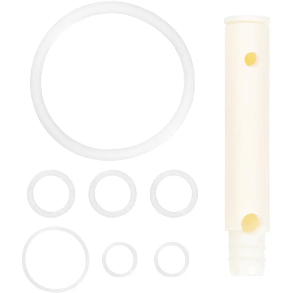 Hvite gummipakninger i ulike størrelser og beige sylinder til italiensk ismaskin, sett ovenfra.