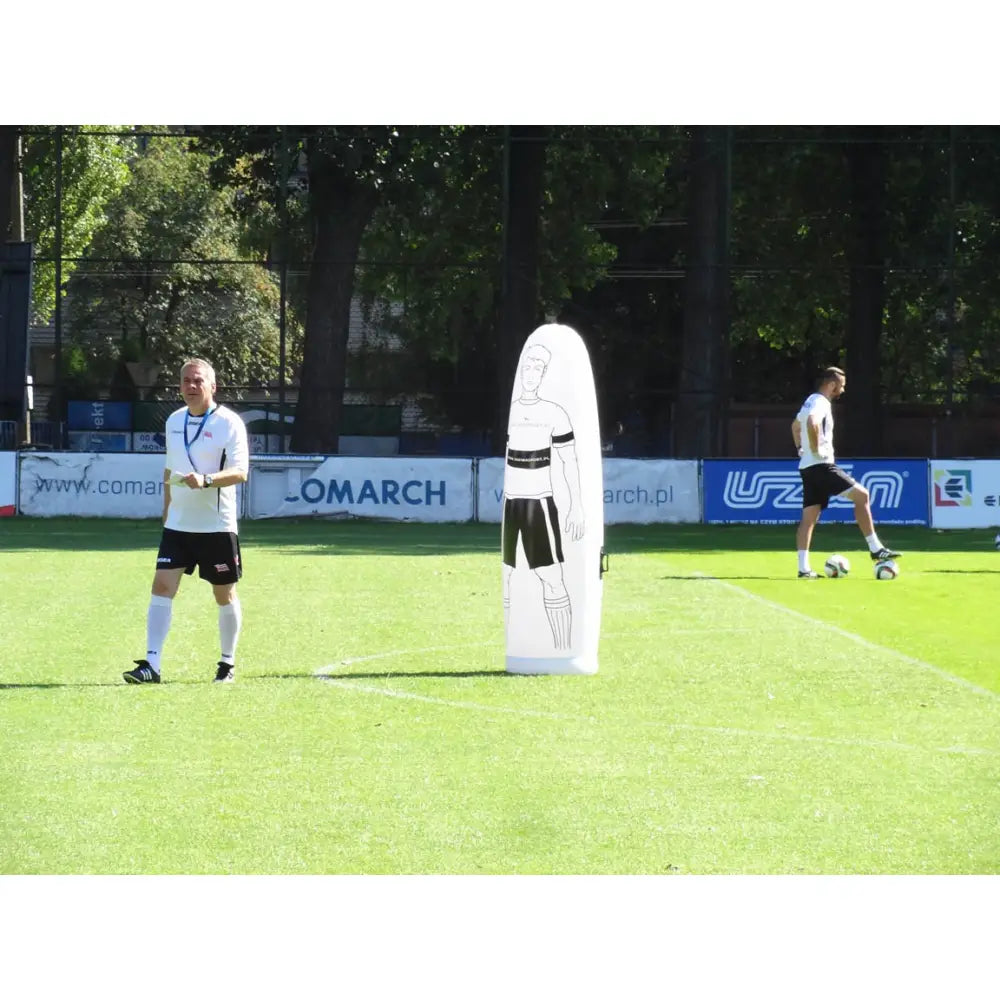 Autooppblåsbar veggdekorasjon figur, hvit treningsfigur med trykt ansikt på fotballbane, to personer trener bak.