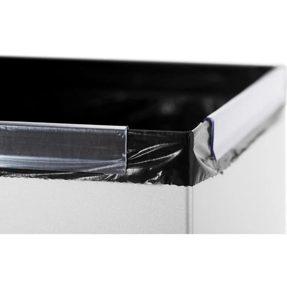 Avfallsbeholder i stål, nærbilde av hjørne med sort pose festet av gjennomsiktige plastklemmer.