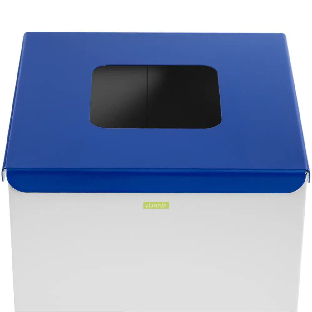 Avfallsbeholder i rustfritt stål med blått lokk, sort rektangulært innkast og grønn logo på fronten.