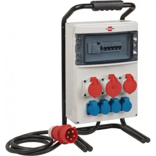 Bærbar byggsentral med hvitt plastskap, svarte detaljer, røde og blå kontakter samt tilkoblingskabel med rød plugg.