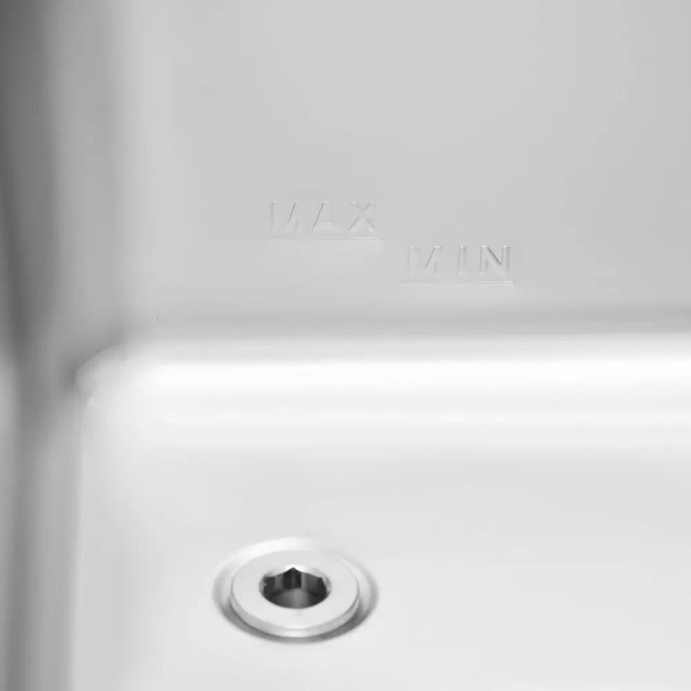 Bain Marie elektriskvarmer, detalj av metallkammer med MAX og MIN-nivå, samt sekskantet skrue nederst.