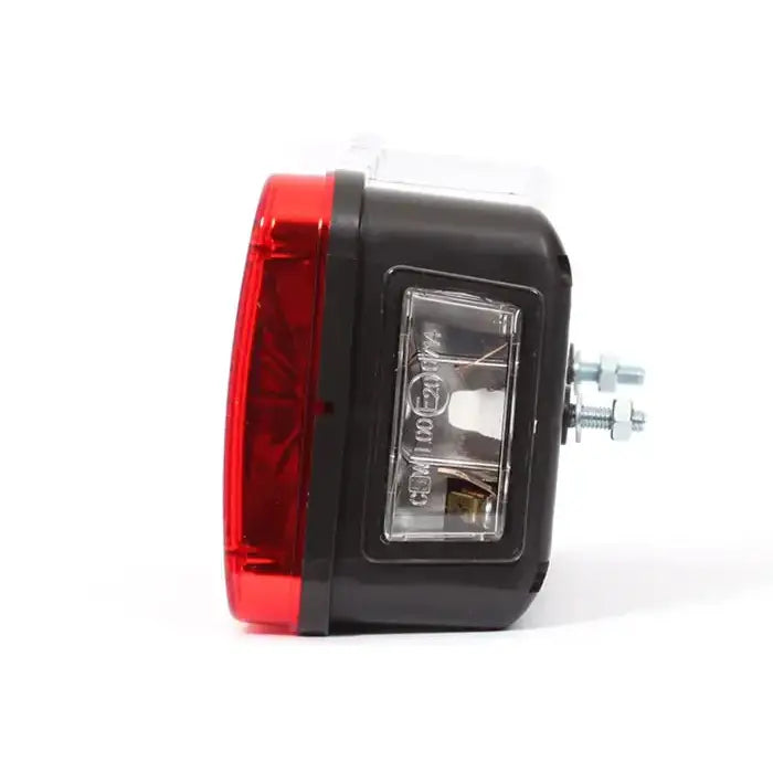 Baklys tilhenger venstre med rød linse og sort plastkropp, sidevisning med synlige skruer og klar innsats.