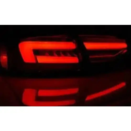 Baklykt Audi A4 B8 LED Bar svart med tydelige røde striper, avbildet nærgående i mørket.