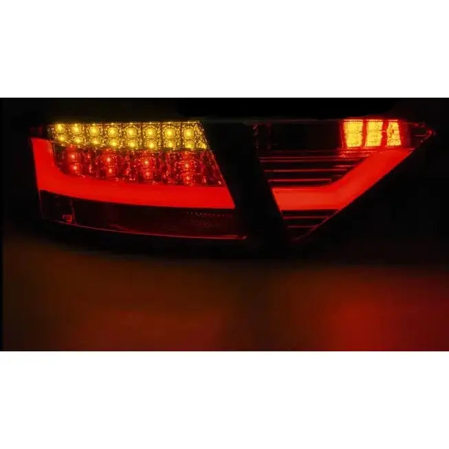 Baklykter Audi A5 Coupe LED med rødt og gult stripemønster, tent i mørket fra skrå vinkel.