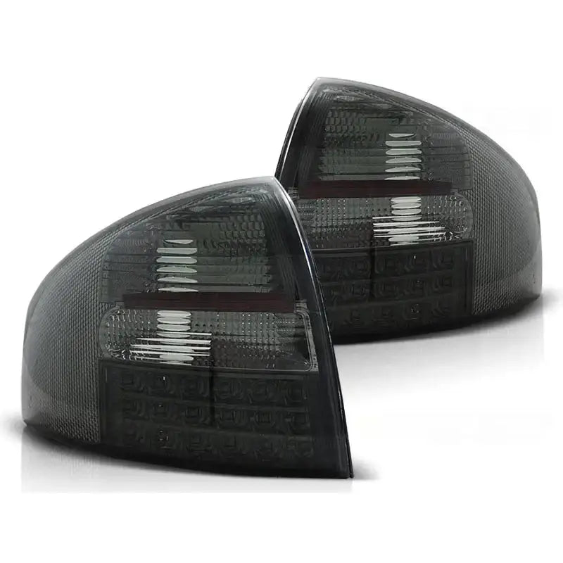Baklykt Audi A6 05.97-05.04 sedan i svart, tonet plast med LED og stripete detaljer, sett skrått forfra.