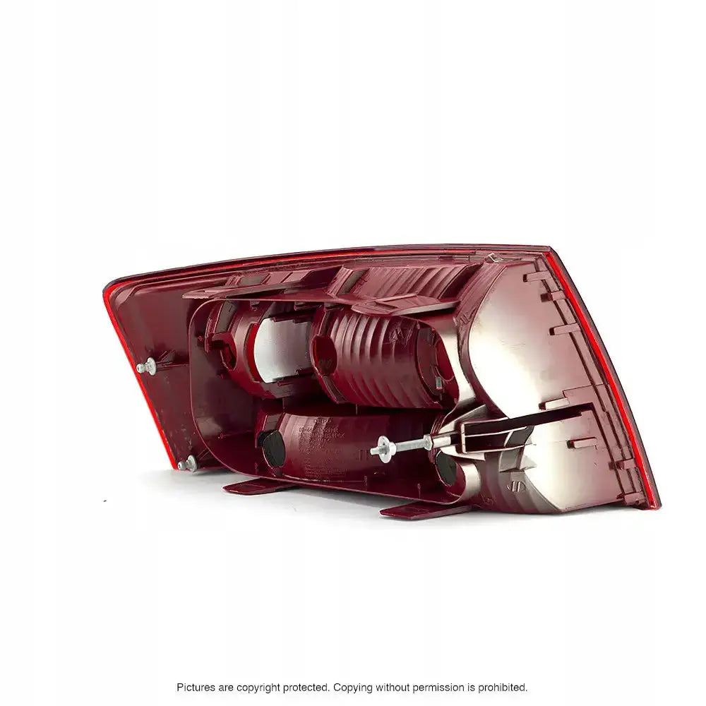 Baklykt Audi A6 C6 bakside med synlige festeanordninger og pæreholdere, vist fra skrå vinkel.