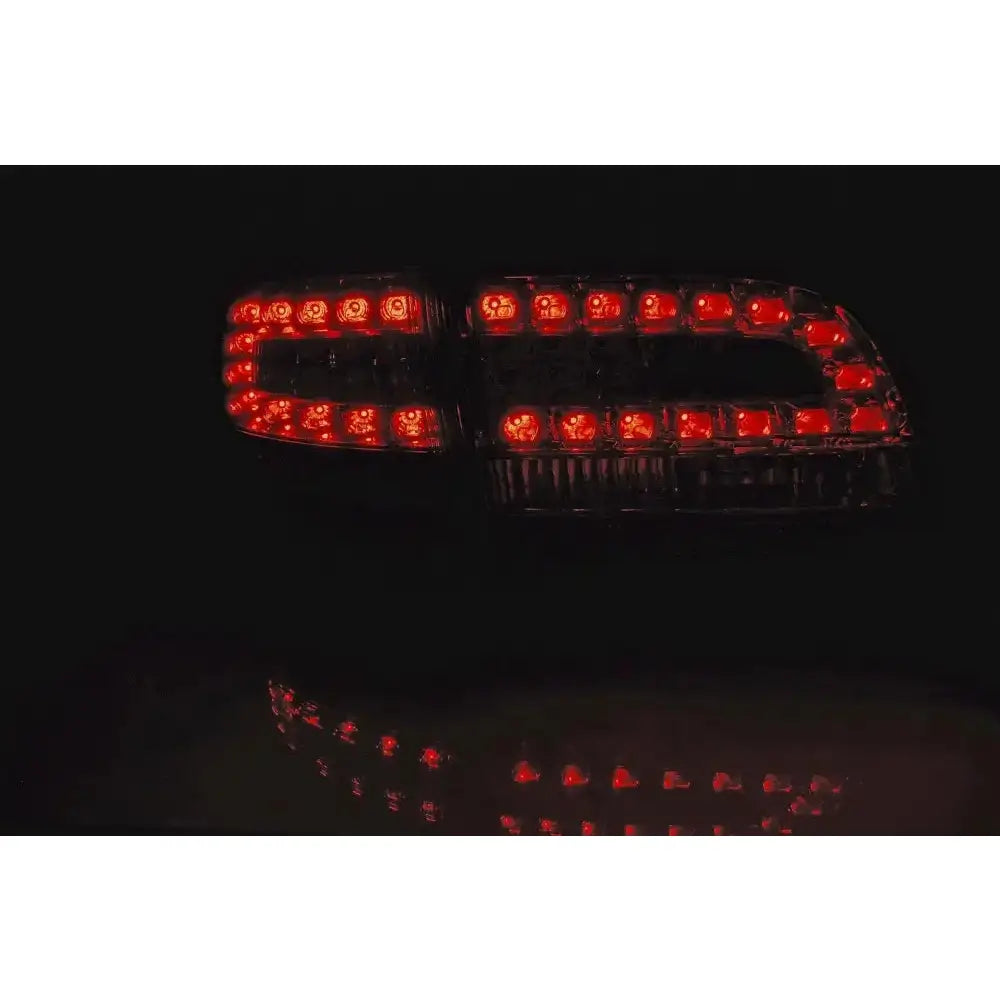 Baklamper Audi A6 C6 05-08 Avant med røde LED-lys sett bakfra, geometrisk mønster i mørket.