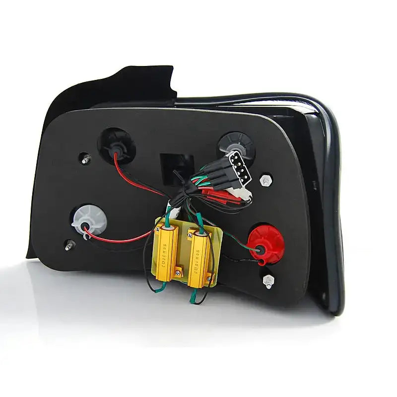 Baklamper Bmw E36 bakside med synlige ledninger, kontakter og festeanordninger mot hvit bakgrunn.