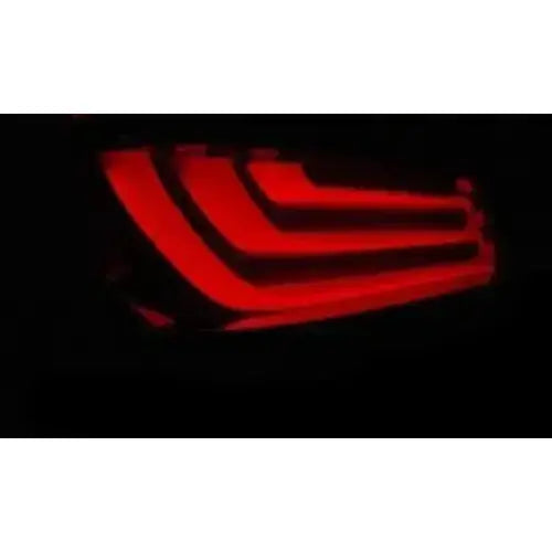 Baklykt Bmw E60 LCI 07-10 med røde LED-striper, sett fra skrå vinkel mot mørk bakgrunn.