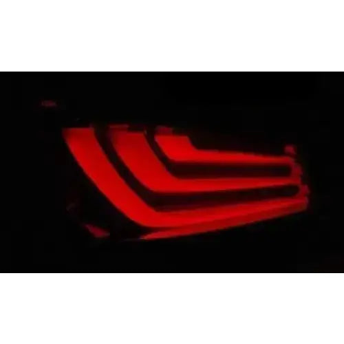 Baklykt Bmw E60 LCI 07-10 LED med røde lyslinjer, svart bakgrunn, sett fra skrå vinkel.