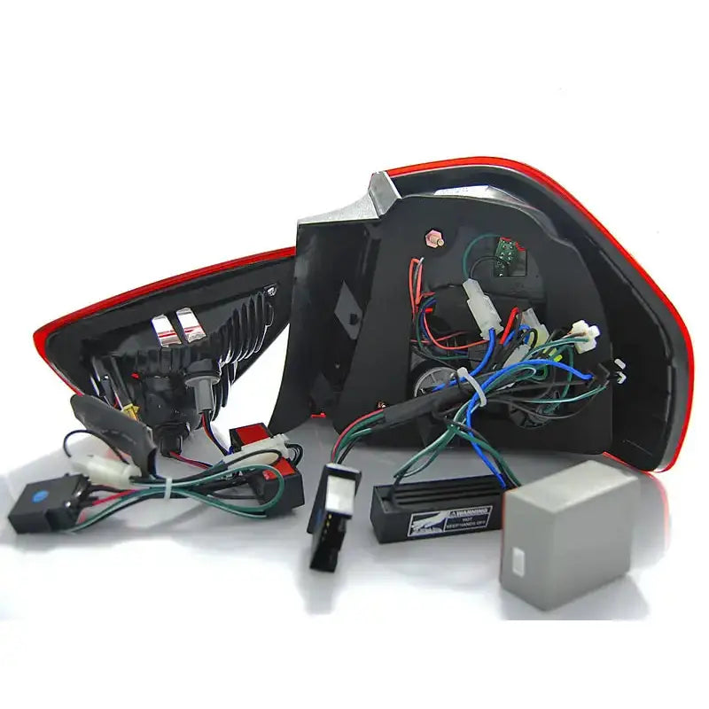 Baklamper Bmw E90 LED bakside med synlige ledninger og elektroniske komponenter på lyst underlag.