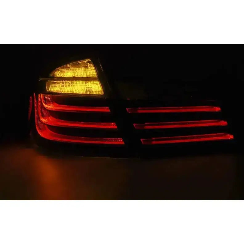 Baklamper Bmw F10 Black Chrome LED Bar LCI sett bakfra med opplyste røde og gule LED-striper.