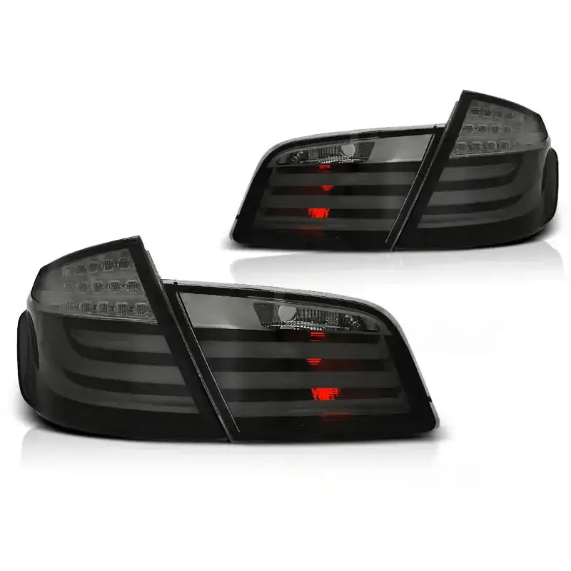 Baklykt Bmw F10 10-07.13 smoke LED bar med sotet finish og røde lysfelt, sett skrått forfra.