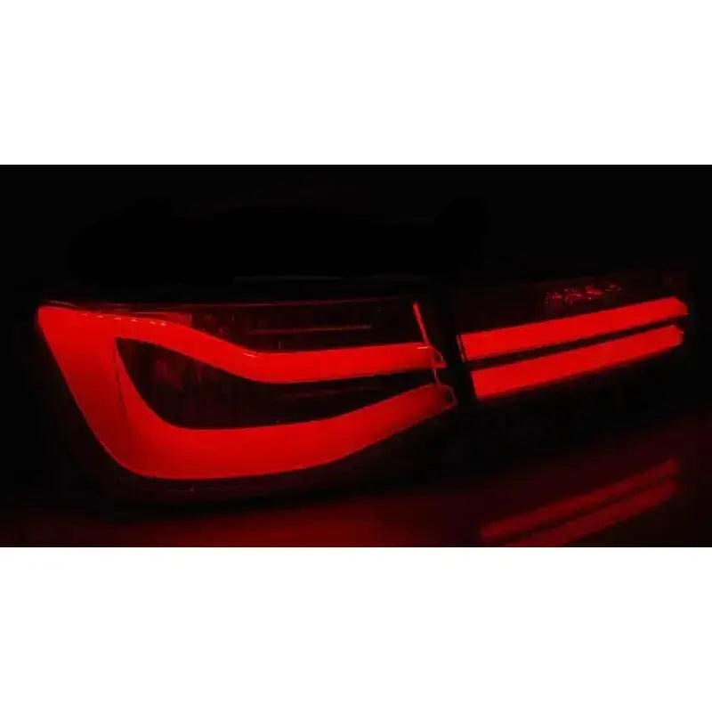 Baklys Bmw F30 11-15 med røde LED-striper i red smoke-design sett bakfra mot svart bakgrunn.