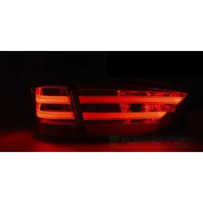 Baklamper Bmw X1 E84 LED sett fra skrå vinkel med opplyste røde striper i mørkt miljø.