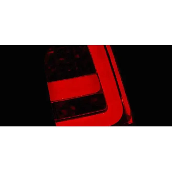 Baklamper Dacia Duster LED Bar Red Smoke, nærbilde av opplyst rød og svart baklykt mot mørk bakgrunn.