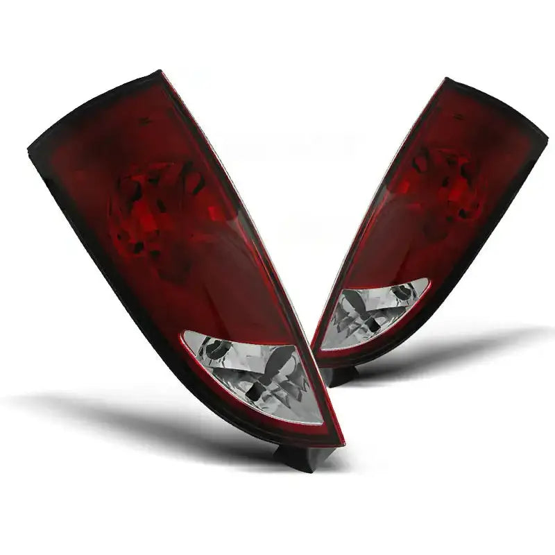 Baklykter Ford Focus 1 i rød og klar plast, avlange med front mot kamera på hvit bakgrunn.
