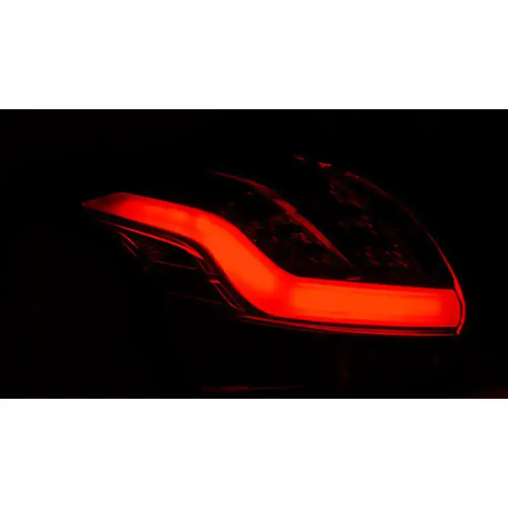 Baklykt Ford Focus 3 hatchback med buet LED-lys, sett fra skrå vinkel i mørket.