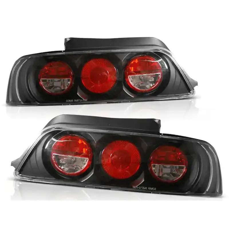 Baklykter Honda Prelude 02.97-01 i sort plast med tre runde røde lysfelt, sett fra skrå vinkel.