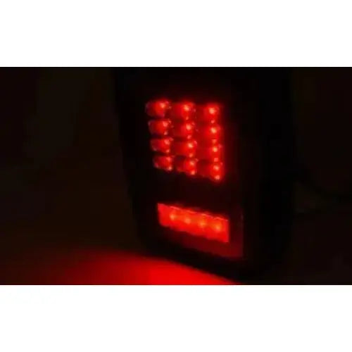 Baklys Jeep Wrangler JK 07-18 LED Black med to rader røde lys sett fra skrå vinkel i mørket.