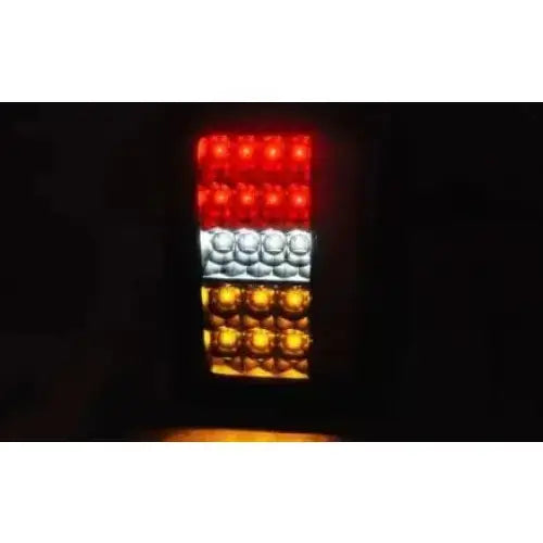 Baklamper Jeep Wrangler JK 07-18 LED Smoke med rødt, hvitt og oransje lys tent i mørket.