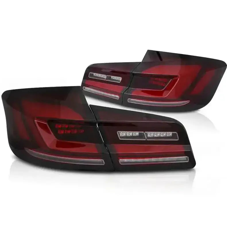 Baklykter LED BMW F10 10-16 i mørkerødt og svart med horisontale lyslinjer, sett fra skrå vinkel.